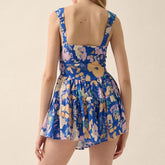 Woman wearing a blue floral dress on a beige background